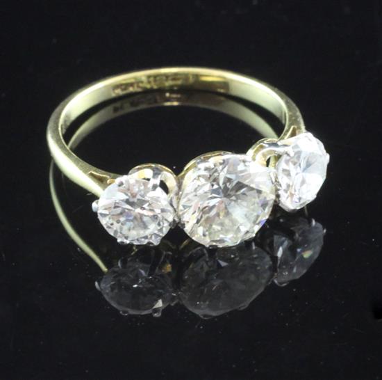 An 18ct gold and platinum three stone diamond ring, size L.